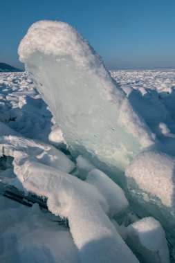 Şeffaf mavi buz kütleleri güneşli bir günde mavi gökyüzüne karşı buz homurdanır. Baykal Gölü 'nün alışılmadık kış manzarası. Doğal soğuk bir geçmişi var. Sibirya, Rusya.
