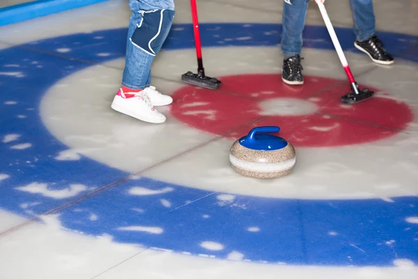 Players curling stones on the ice