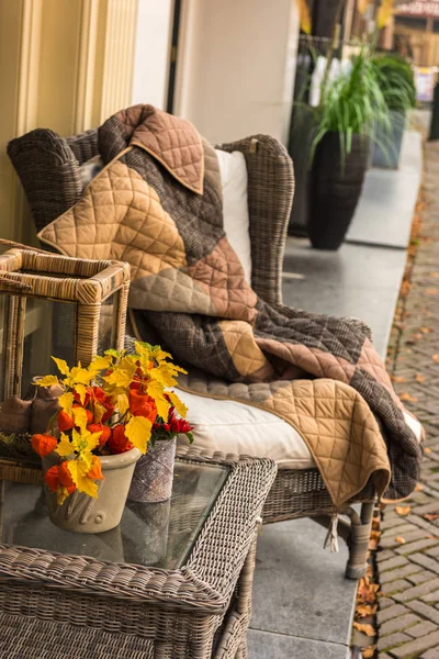 Sillón acogedor de mimbre con manta — Foto de Stock