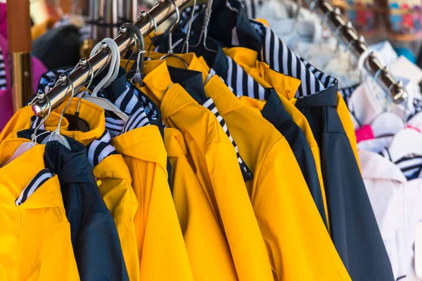 Jasne płaszcze wiszące o sklep odzieżowy — Zdjęcie stockowe