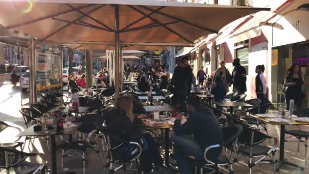 La gente sentada en un café al aire libre en la calle de — Vídeos de Stock