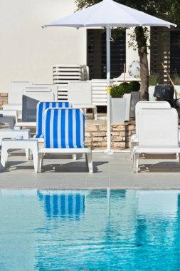 şezlong ve şemsiyeler havuz kenarında