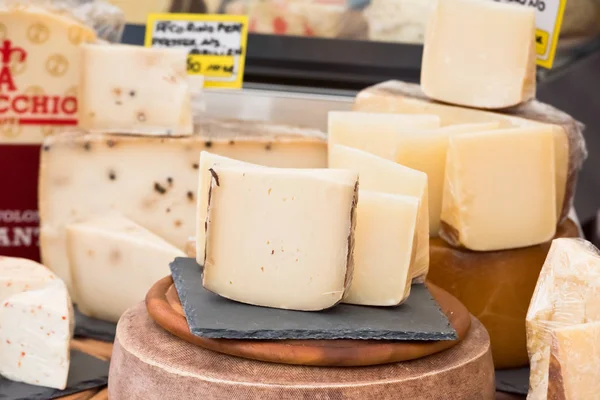 Pedaços de queijos diferentes num mercado europeu local — Fotografia de Stock