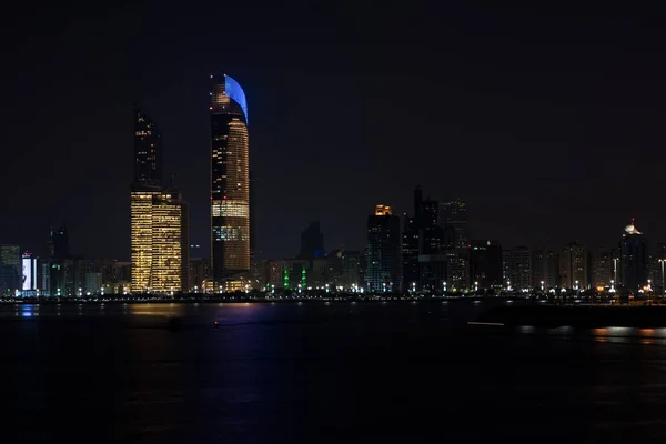 Абу-Дабі будівель skyline від моря на ніч — стокове фото
