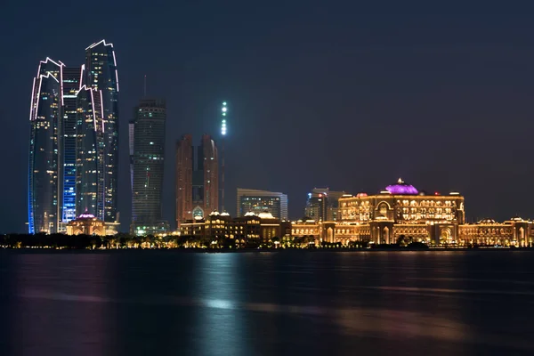 Edificios de Abu Dhabi horizonte desde el mar por la noche — Foto de Stock