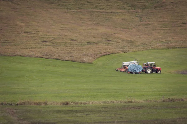 Трактор с плугами на исландском поле — стоковое фото