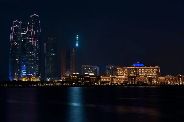 Abu Dhabi byggnader skyline från havet på natten — Stockfoto