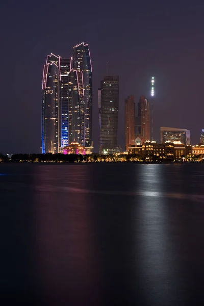 Abu Dhabi edifícios skyline do mar à noite — Fotografia de Stock