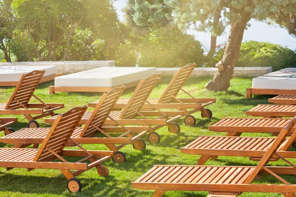 Cadeiras da piscina do hotel em um prado verde — Fotografia de Stock