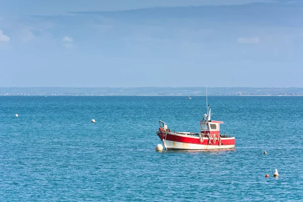 Ярко-синее море и рыбацкая лодка — стоковое фото