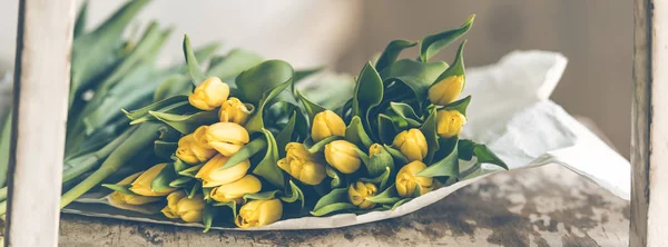 Yellow tulips flowers bouquet on a wooden table — Stock Photo, Image