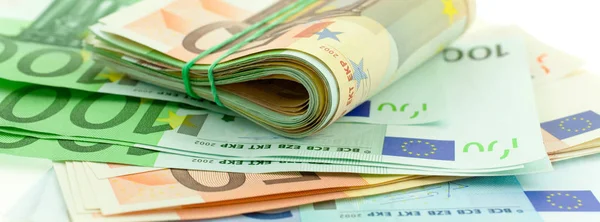 Rotolato con banconote in euro in gomma su fondo bianco — Foto Stock