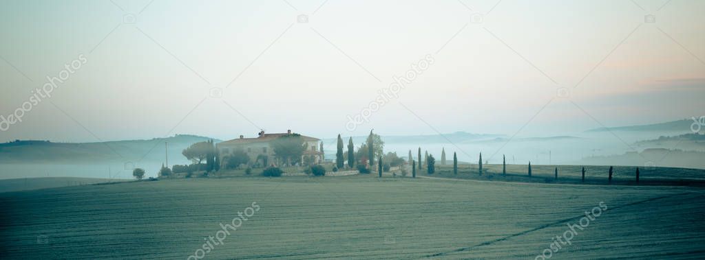 Morning fog view on farmhouse in Tuscany, Italy