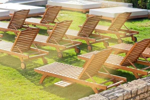 Chaises d'hôtel au bord de la piscine sur prairie — Photo