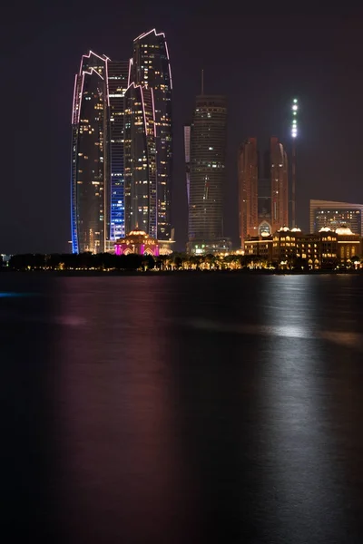 Skyline van Abu Dhabi gebouwen uit de zee bij nacht — Stockfoto