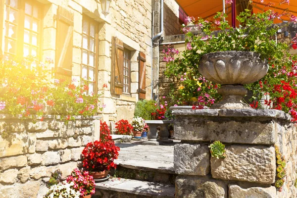 Helle Blumentöpfe auf einem alten Steinhaus in Frankreich — Stockfoto