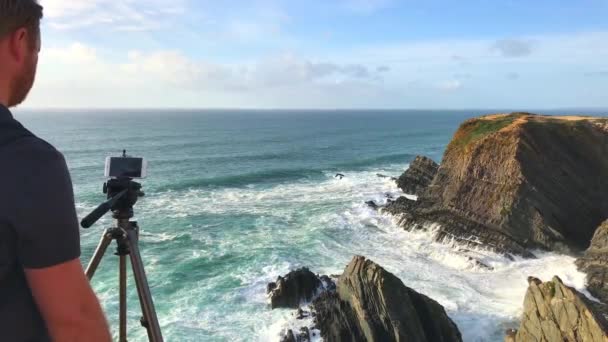 2017 日に彼のスマート フォンでポルトガルの岩海海岸のポルトガル Odeceixe 写真撮影 — ストック動画