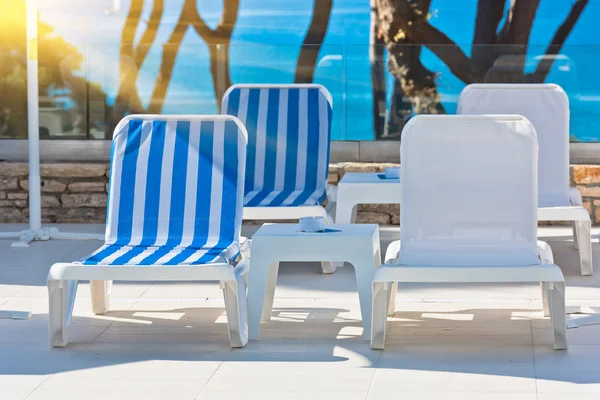 Sunbeds and umbrellas by the swimming pool on a sunny day — Stock Photo, Image