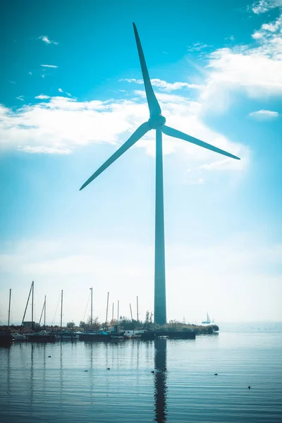 Landsbygdens vatten landskap med fungerande vindkraftverk — Stockfoto