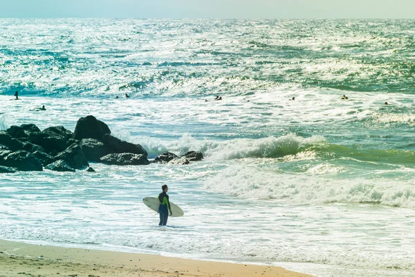 Surfers rijden enkele golven op de zee — Stockfoto