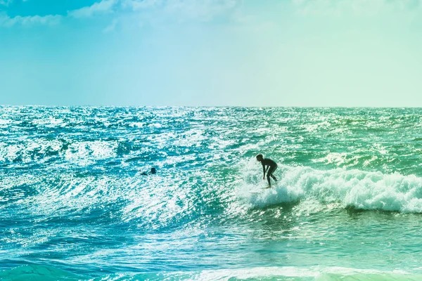 冲浪者乘坐海浪在海面上 — 图库照片