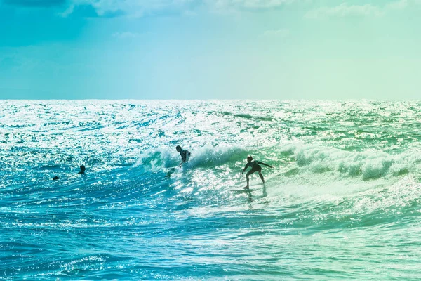 Surfers rijden enkele golven op de zee — Stockfoto