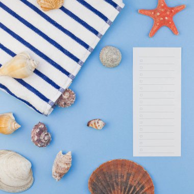 Yaratıcı kare düz yaz seyahat tatil kavramı yatıyordu. Kopya alanı en az tarzı, metin için şablon pastel mavi zemin üzerine plaj havlusu ve kabukları ve denizyıldızı Üstten Görünüm