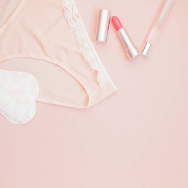 Kare kadınsı düz metin için kopya yer moda blog ve sosyal medya için pastel pembe renk zemin üzerine kadın iç çamaşırı ve aksesuarları, parfüm, ruj ve yastıkları gömlekleri set koymak