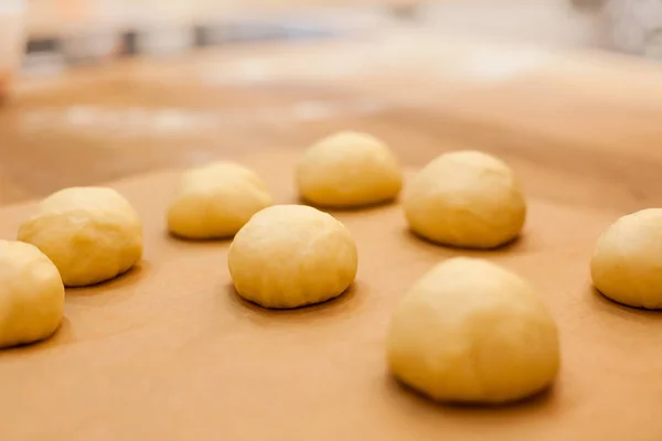 Rauwe zelfgemaakte broodjes op keukentafel in de maak — Stockfoto