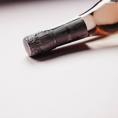 Pembe arka planda gül şampanya şarap şişesi