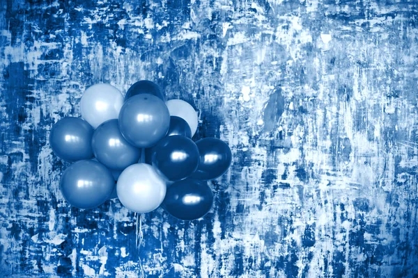 Bouquet de ballons contre un mur texturé ton bleu — Photo