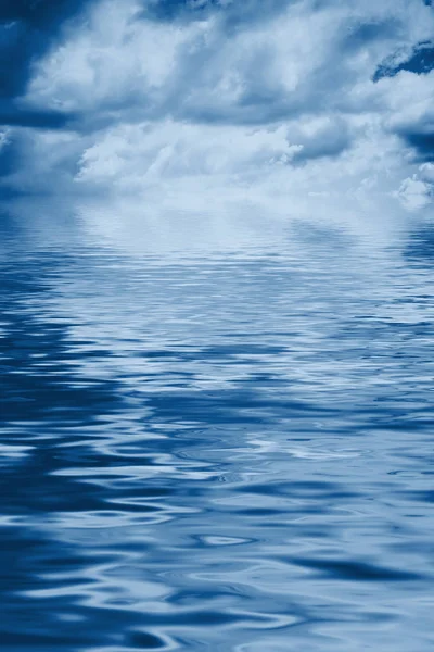 Fundo de água com céu nublado azul tonificado — Fotografia de Stock