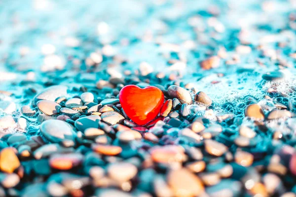 Romantic symbol of red heart on the pebble beach — Stock Photo, Image