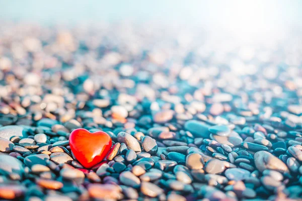 Romantic symbol of red heart on the pebble beach — Stock Photo, Image