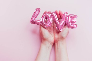 Aşk konsepti. Şişirilebilir pembe balon ellerinde