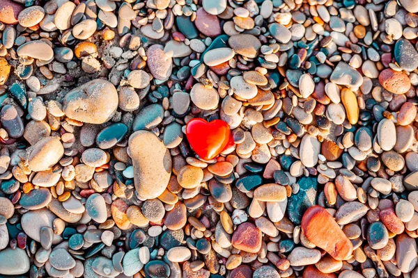 Romantic symbol of red heart on the pebble beach — Stock Photo, Image