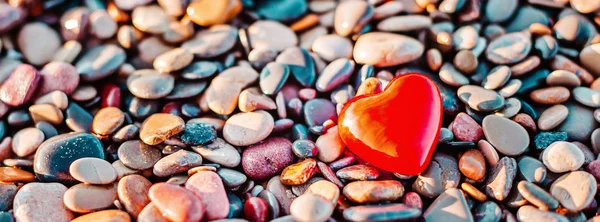 Romantic symbol of red heart on the pebble beach — Stock Photo, Image