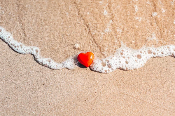 Romantic symbol of red heart on the sand beach — Stock Photo, Image