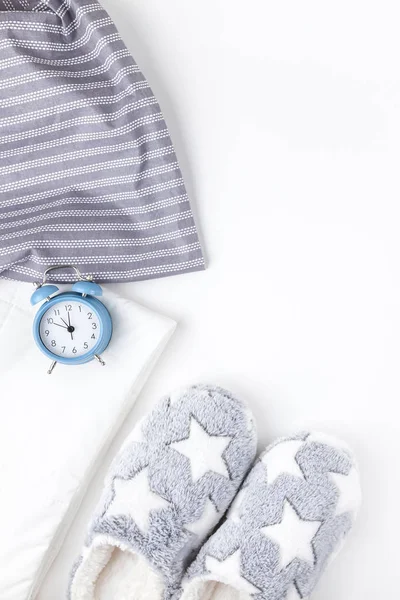 Mjuka fluffiga tofflor och blå väckarklocka — Stockfoto