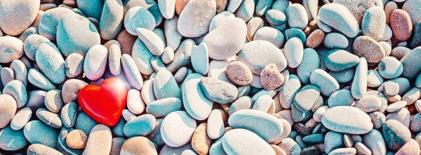 Romantic symbol of red heart on the pebble beach — Stock Photo, Image