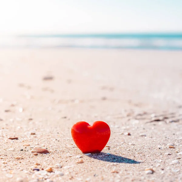 Romantic symbol of red heart on the sand beach — Stock Photo, Image