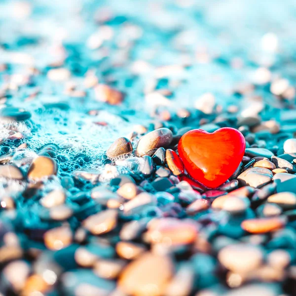 Romantic symbol of red heart on the pebble beach — Stock Photo, Image