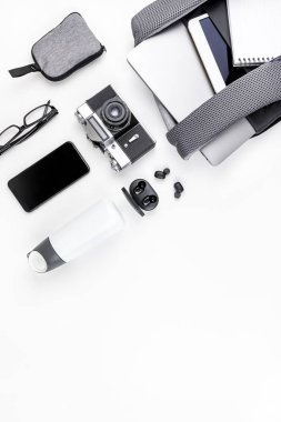 Yaratıcı üst görünüm düz dizüstü bilgisayar ve tablet ile açık sırt çantası yatıyordu, cep telefonu, kopyalama alanı beyaz arka plan minimal tarzı. Eğitim, iş ve yaşam için Modern adam aksesuarları kavramı