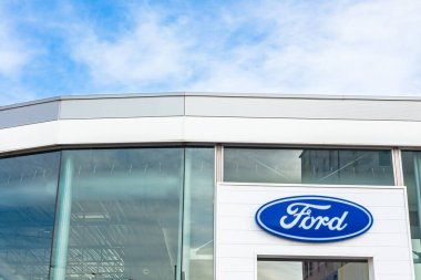 Ford Motor Şirketi 'nin Lyon, Fransa' daki araba satıcısı ofis binasında bulunan parlak mavi gökyüzü arka planının logosu - 23 Şubat 2020