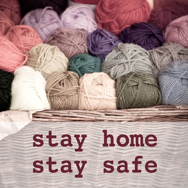 Stay home stay safe concept with colorful wool thread balls and text. Spending quality family time home with homework during Coronavirus pandemic quarantine isolation