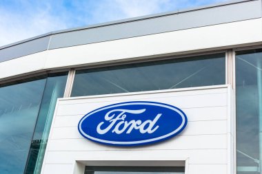 Ford Motor Şirketi 'nin Lyon, Fransa' daki araba satıcısı ofis binasında bulunan parlak mavi gökyüzü arka planının logosu - 23 Şubat 2020
