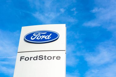 Ford Motor Şirketi 'nin Lyon, Fransa' daki araba satıcısı ofis binasında bulunan parlak mavi gökyüzü arka planının logosu - 23 Şubat 2020
