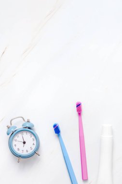 Fotokopi alanı olan beyaz mermer masa zemininde mavi alarmlı diş ve ağız bakımı ürünleri. Boş diş macunu ve fırça tüpü. Düz konum, üst görünüm bileşimi, model