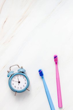 Fotokopi alanı olan beyaz mermer masa zemininde mavi alarmlı diş ve ağız bakımı ürünleri. Boş diş macunu ve fırça tüpü. Düz konum, üst görünüm bileşimi, model