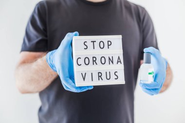 El hijyen önleyici alkol jeli şişeleri ve ışık kutusu. Coronavirus 'u durdurun. Koronavirüs COVID 19 salgını sırasında lateks eldiven ve koruyucu maske takan adamın ellerinde. Sağlık Hizmetleri